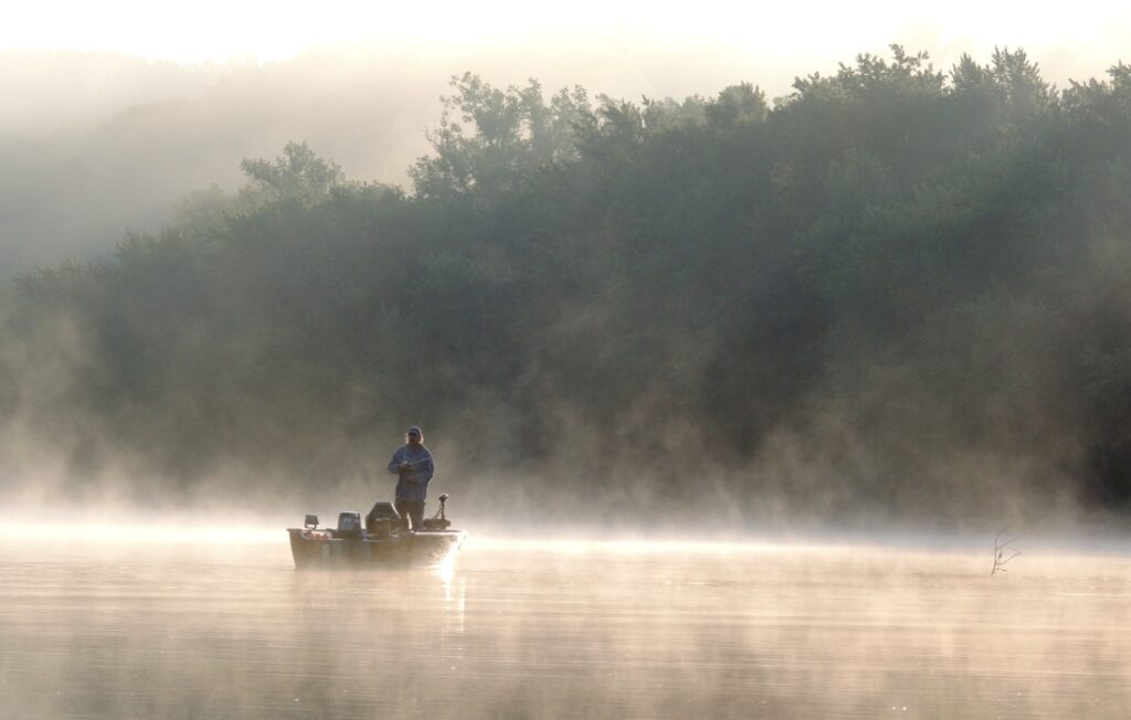 Man fishing on a foggy morning on the lake